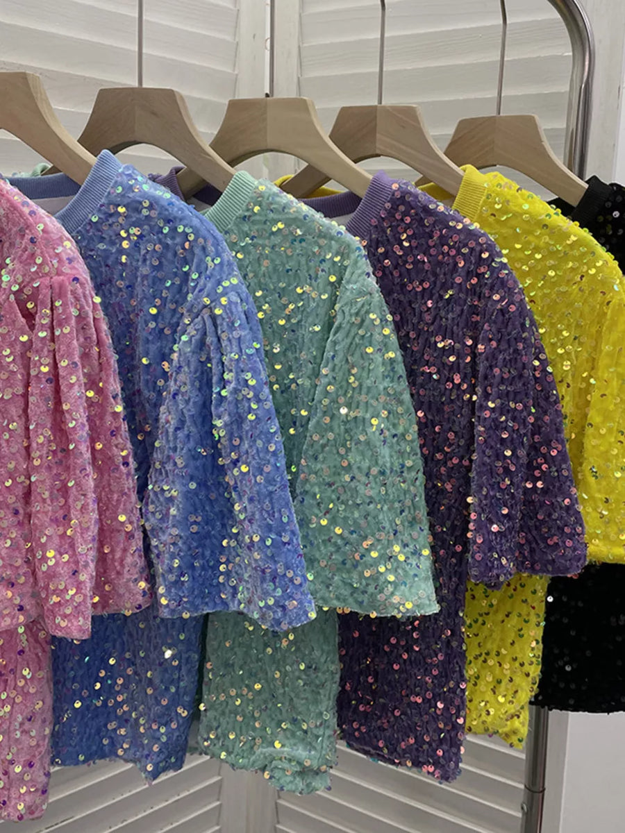 Iridescent sequin embellished t-shirts in pink, blue, green, purple, yellow, and black.