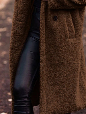 Brown teddy bear longline coat with button detail and pocket, styled with black faux leather pants.