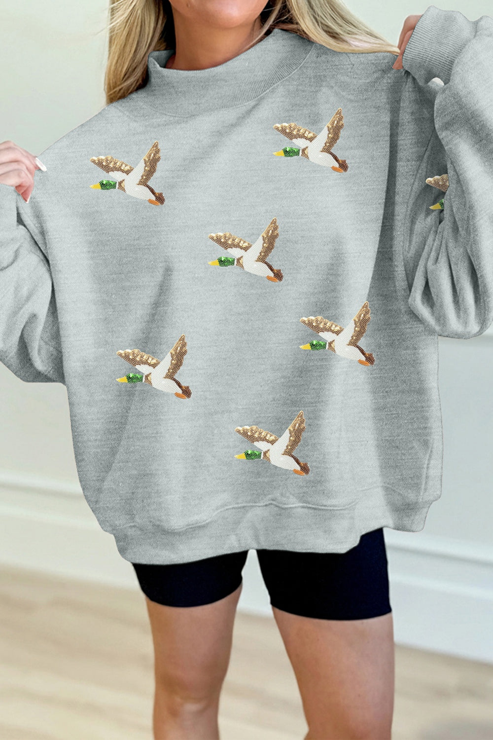 light gray sweatshirt with graphic print and mock neck
