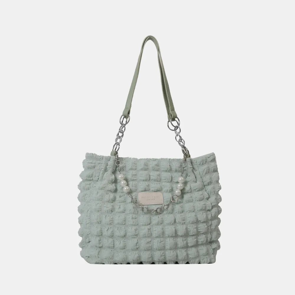 Light green textured grid pearl chain tote bag with chain and pearl detail.