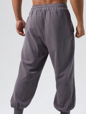 Relaxed fit dark gray joggers with adjustable waistband and seam details.