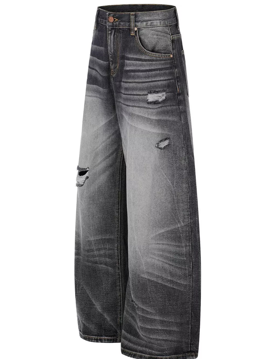 Men's black distressed wide-leg jeans with ripped details and faded wash.