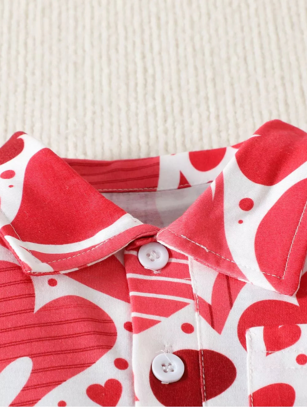 Red and white heart print cotton polo shirt with button closure for babies.