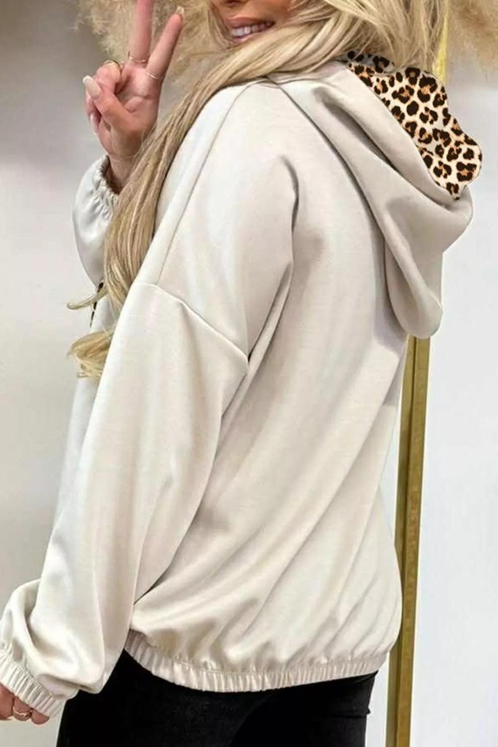 Beige pullover hoodie featuring drawstring and leopard-print