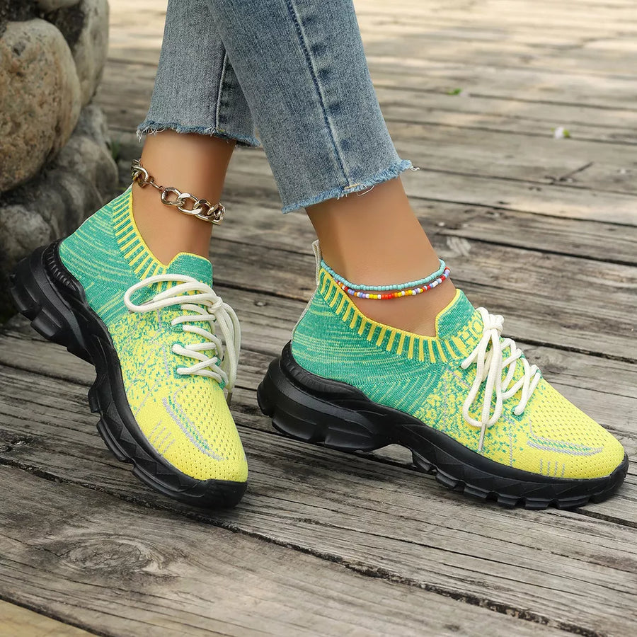 Vibrant two-tone knit lace-up sneakers with chunky black soles and ankle accents.