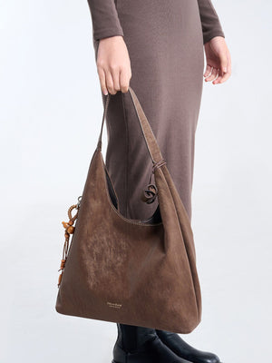 handbag in dark brown featuring decorative tassel and relaxed fit