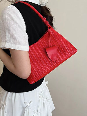 Red woven shoulder bag with braided strap and flap closure detail