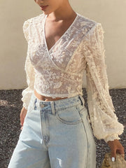 White lace sheer long sleeve wrap blouse with floral applique detail.