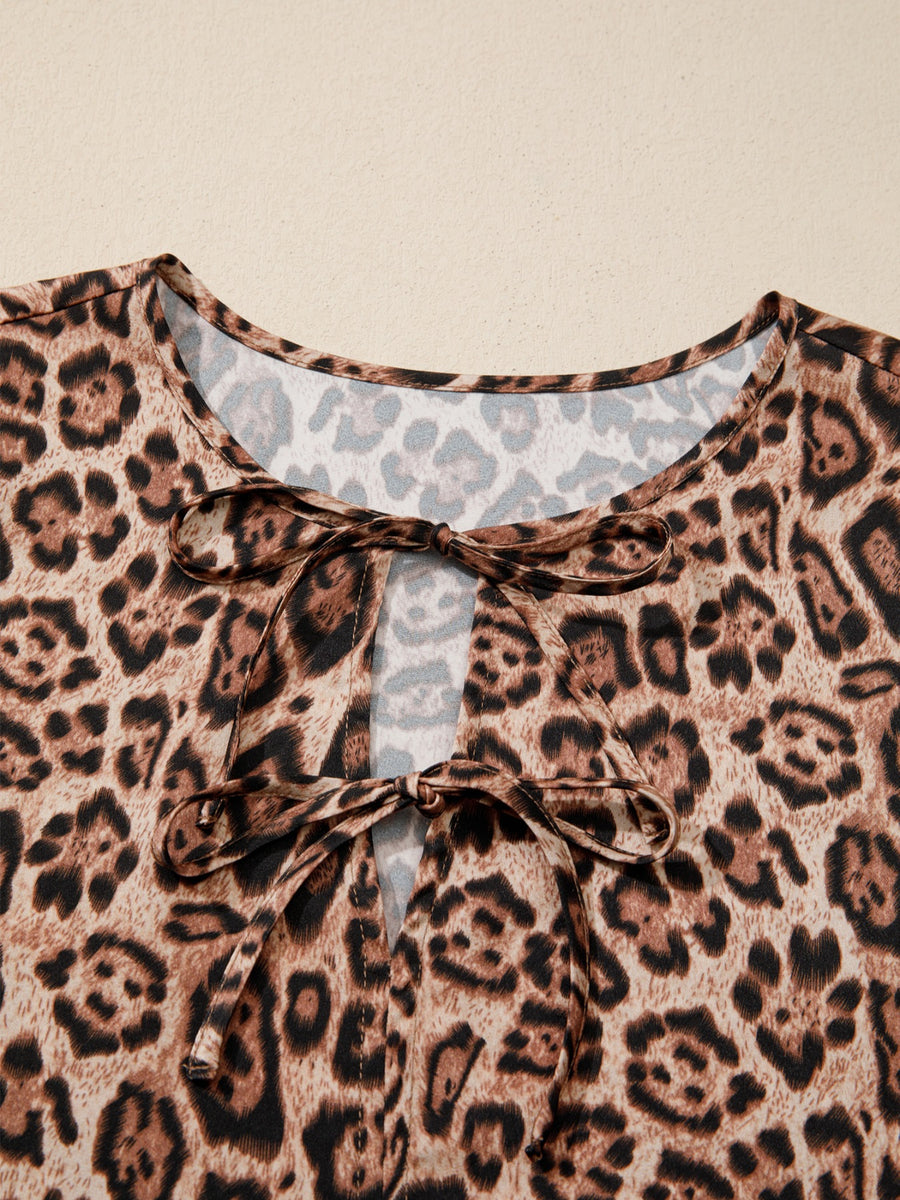 Leopard print blouse with tie neck detail and puff sleeves.