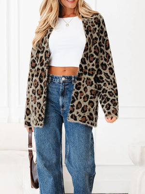 Leopard print fuzzy cardigan with pockets and long sleeves, worn open over a white crop top and jeans.
