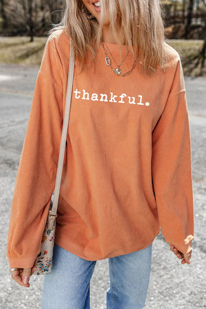 Orange corduroy pullover sweatshirt with white "thankful" graphic and crew neck.