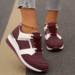 Burgundy lace-up sneakers with white accents and metallic details.