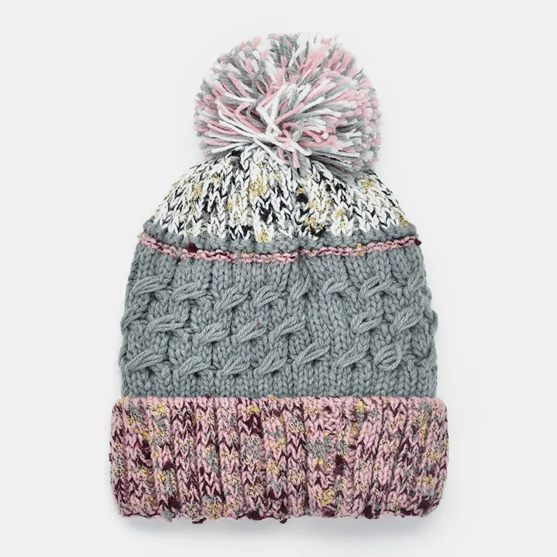 Textured cable knit beanie with a multicolor pompom and pink trim.