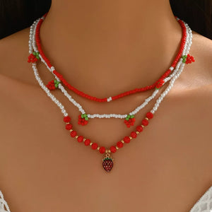 white necklace featuring beaded and strawberry motif