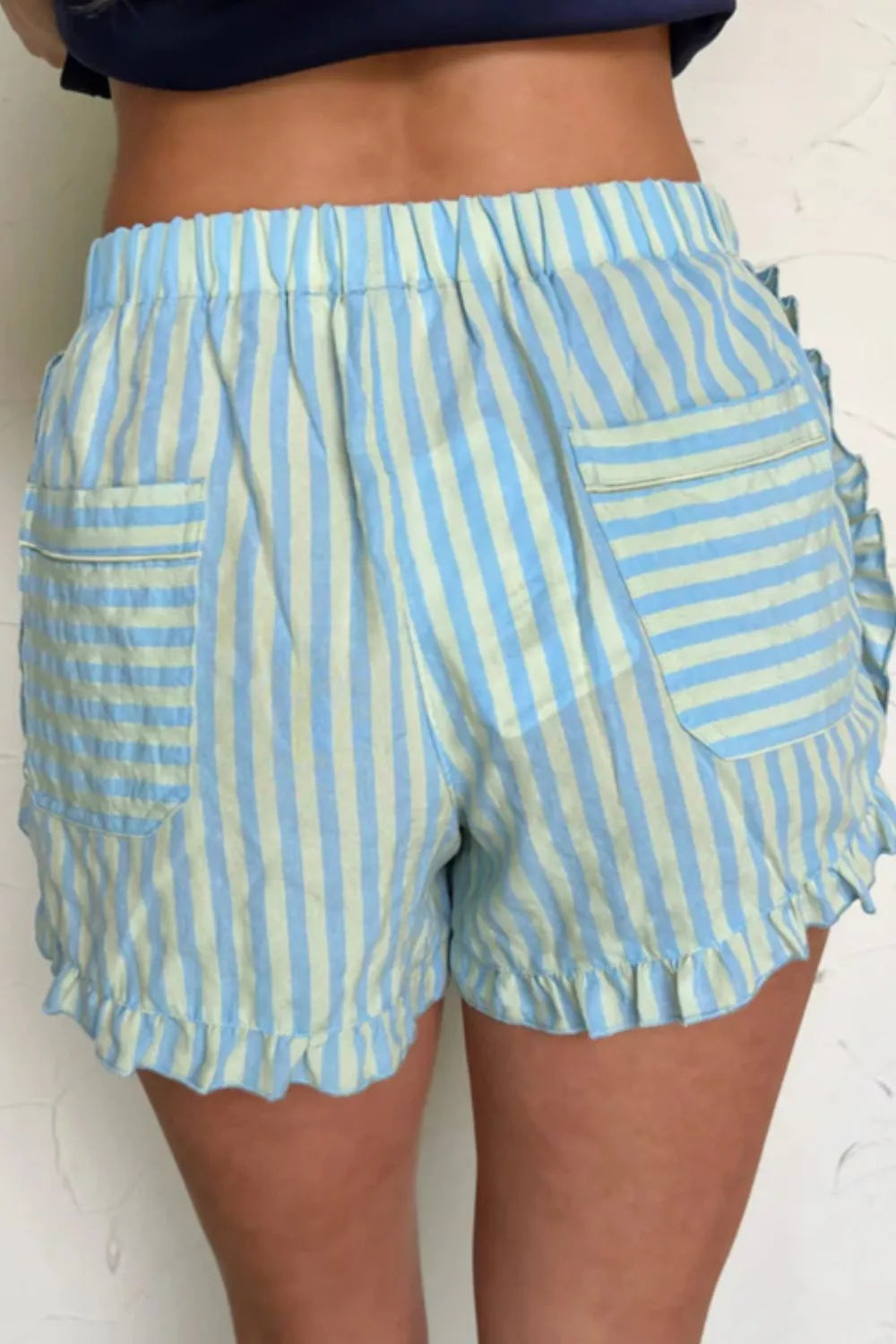 Blue and green striped cotton shorts with ruffled hem and pockets.