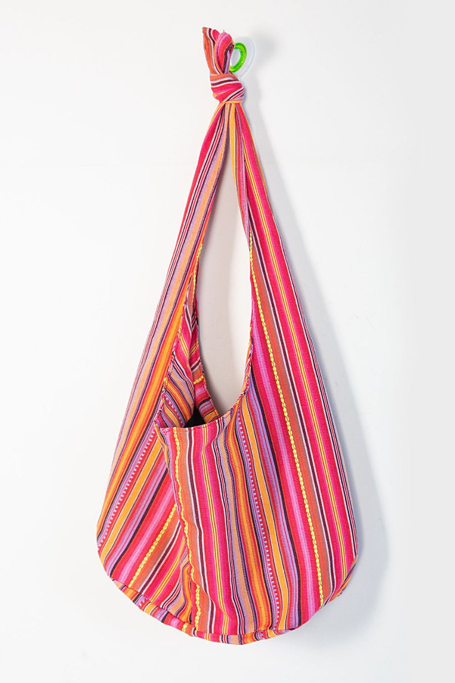 Tribal weave shoulder bag in multicolor stripes with a front pocket and knotted strap.