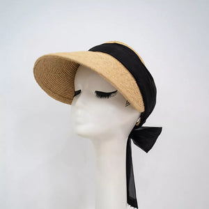 Straw visor hat with black ribbon tie and beaded detail.