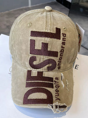 Beige distressed baseball cap with large dark brown embroidered text and frayed details.