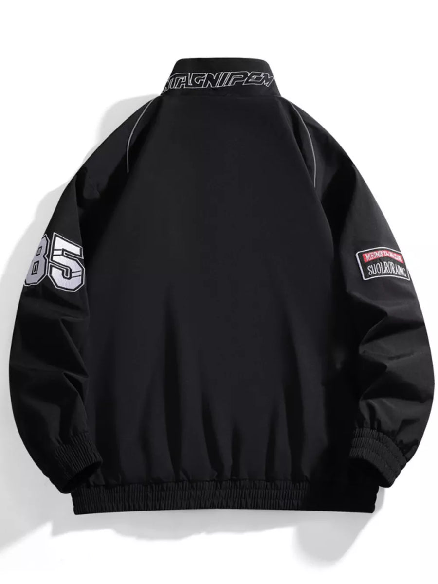 Black bomber jacket with racing-inspired details, "85" on sleeve, and embroidered patches.