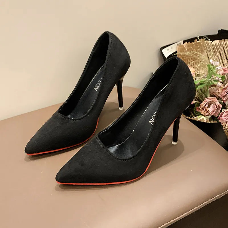 Black pointed stiletto pumps with crimson soles and a suede finish.