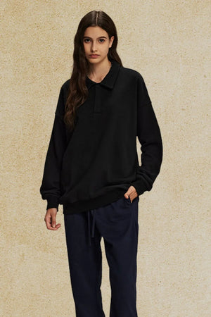 Black oversized polo sweatshirt with collar and long sleeves.