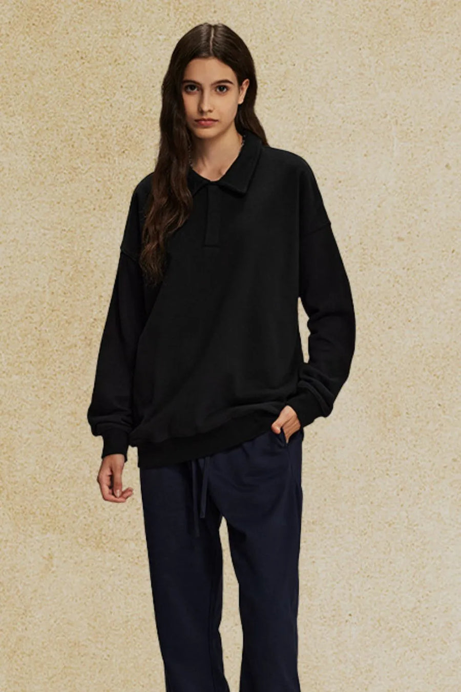 Black oversized polo sweatshirt with collar and long sleeves.
