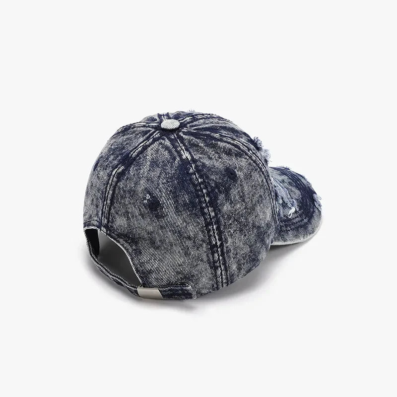Acid wash distressed denim baseball cap with frayed details.