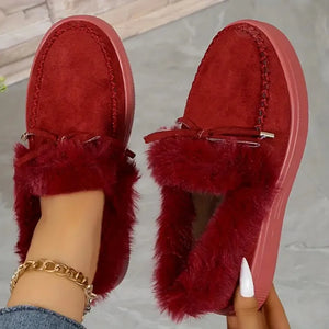 Red suede loafers with shearling trim and bow detail.