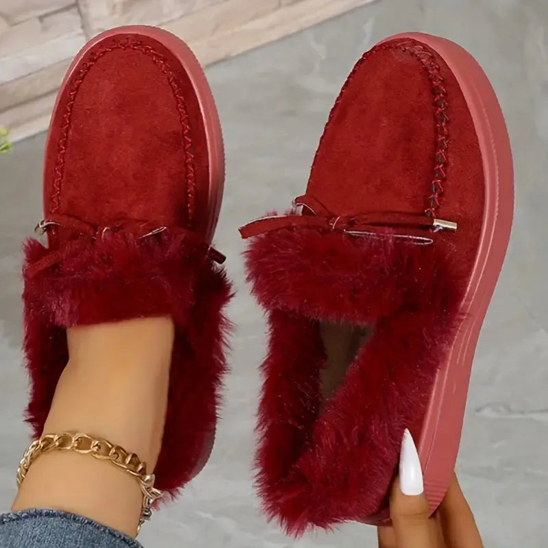Red suede loafers with shearling trim and bow detail.