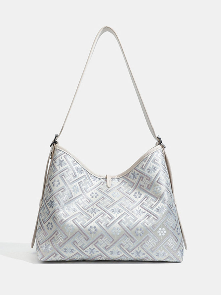 light blue handbag featuring adjustable strap and geometric
