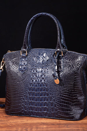 Dark Blue crocodile embossed satchel bag with top handles and shoulder strap detail.