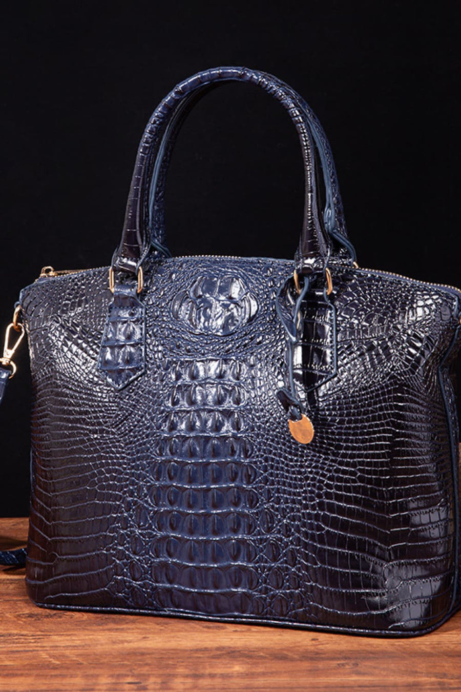 Dark Blue crocodile embossed satchel bag with top handles and shoulder strap detail.