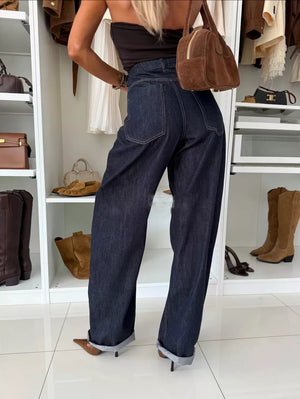 High-waisted wide-leg jeans in dark navy denim with cuffed hems.