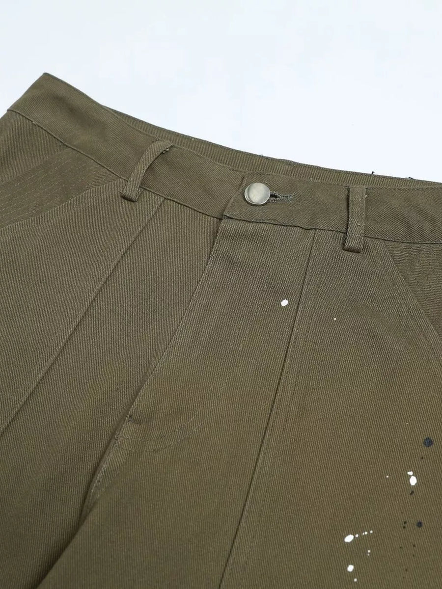 Olive green cotton cargo pants with white and black paint splatter detail and button fly.