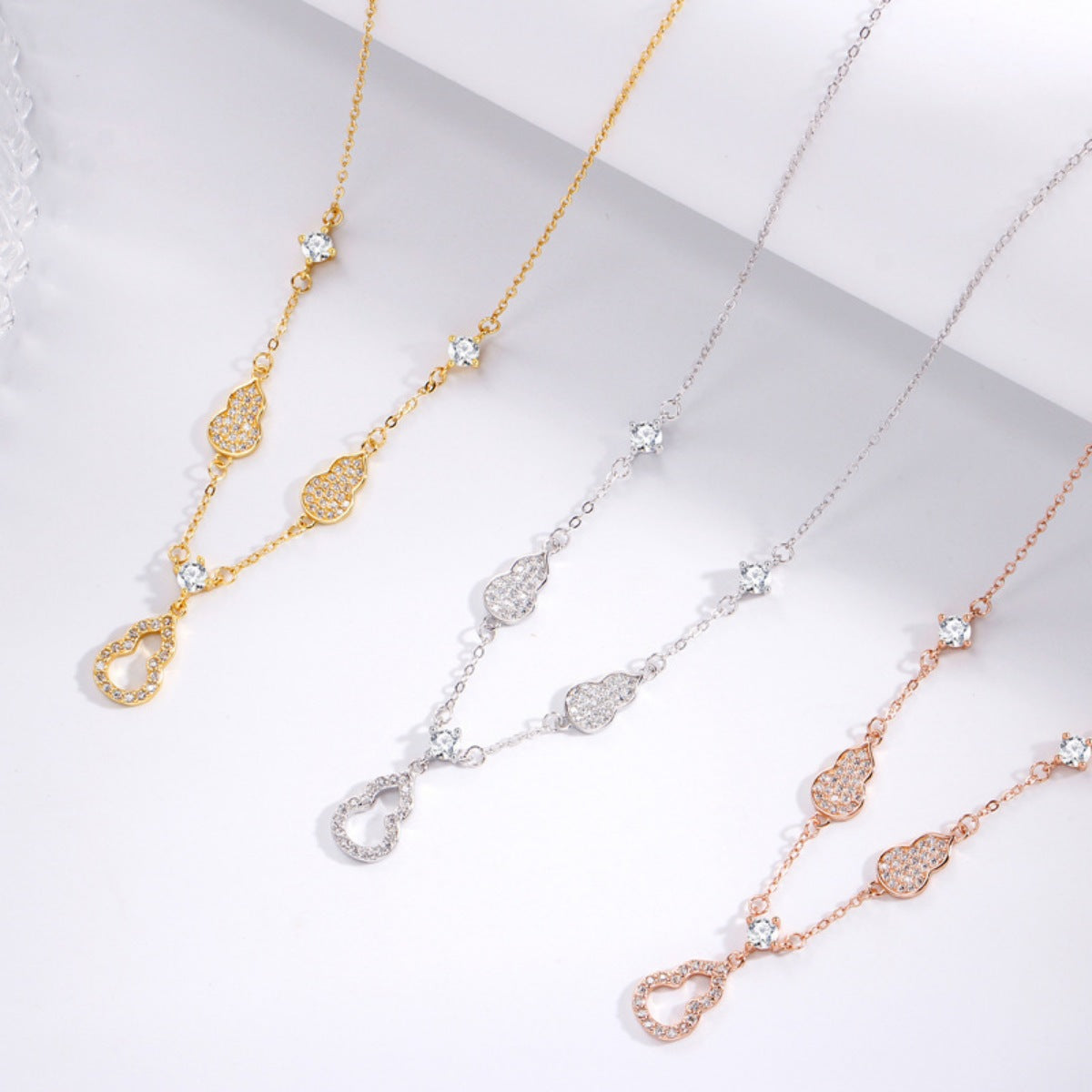Zircon adorned Y-lariat necklace in gold, silver, and rose gold with delicate gourd charms.