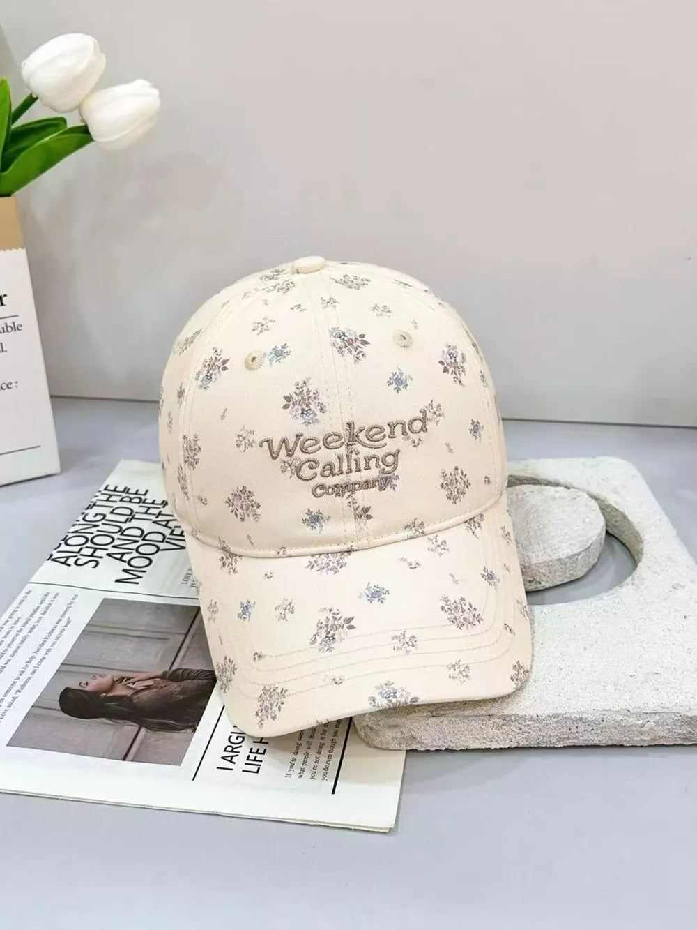 Ivory cotton baseball cap with all-over floral print and embroidered text.