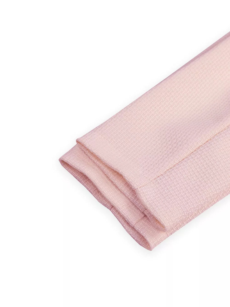 Pink textured fabric folded, showing hem detail.