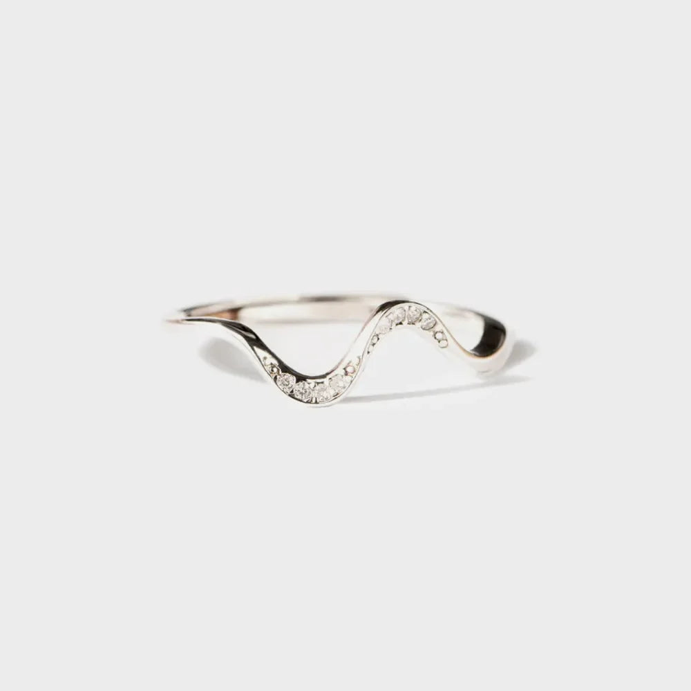 Serpentine diamond contour ring in silver with a wavy design and sparkling stones.