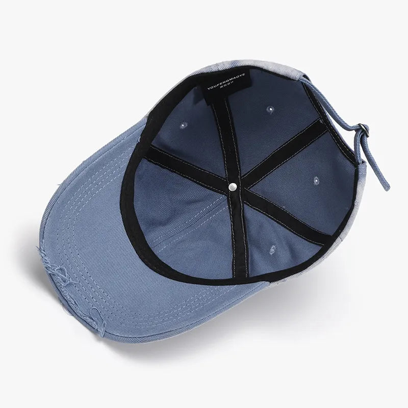 Distressed light blue denim baseball cap with adjustable strap and interior label.