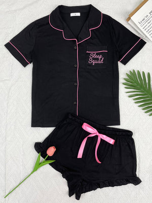 Black pajama set with pink trim and shorts with a pink bow