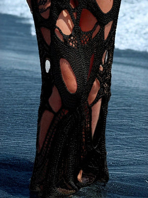 Black crochet dress with large cutouts, showing skin underneath.