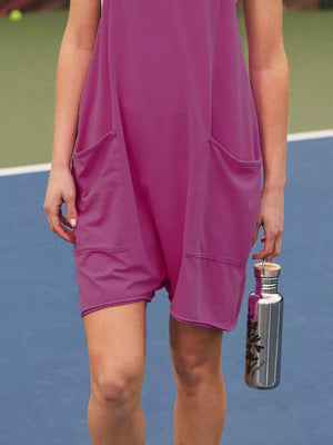 Purple sleeveless romper with large front pockets and a silver water bottle.