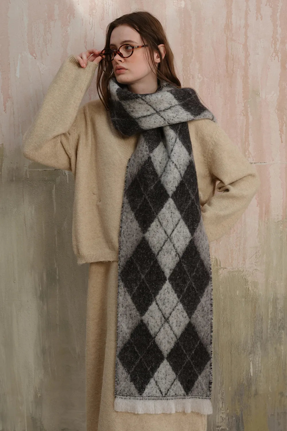 Argyle knit scarf in black and grey with fringe detail and frayed edges.