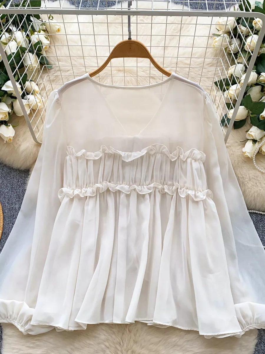 White chiffon blouse with ruffled V-neck and tie-front detail, long sleeves.