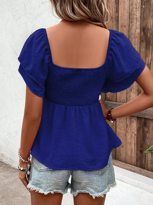 Royal blue textured smocked blouse with ruffled sleeves and square neckline.