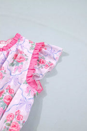 Floral tiered ruffle dress with pink roses and bows on a light pink polka dot background.