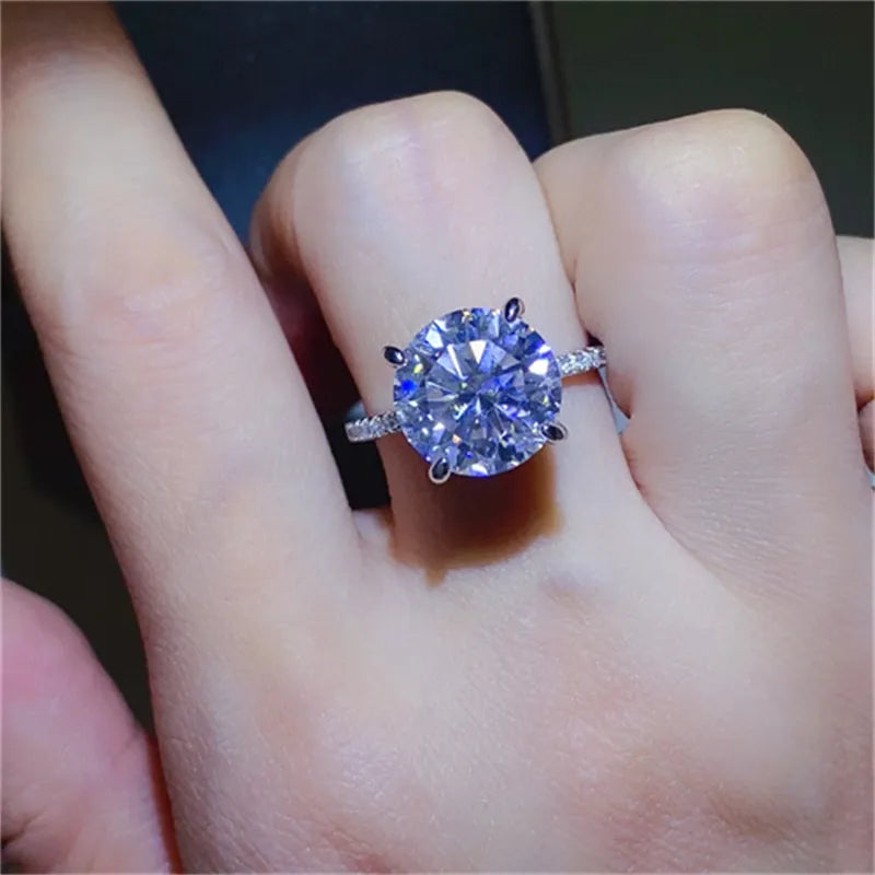 Sterling silver ring with a large round solitaire diamond and small accent stones on the band.