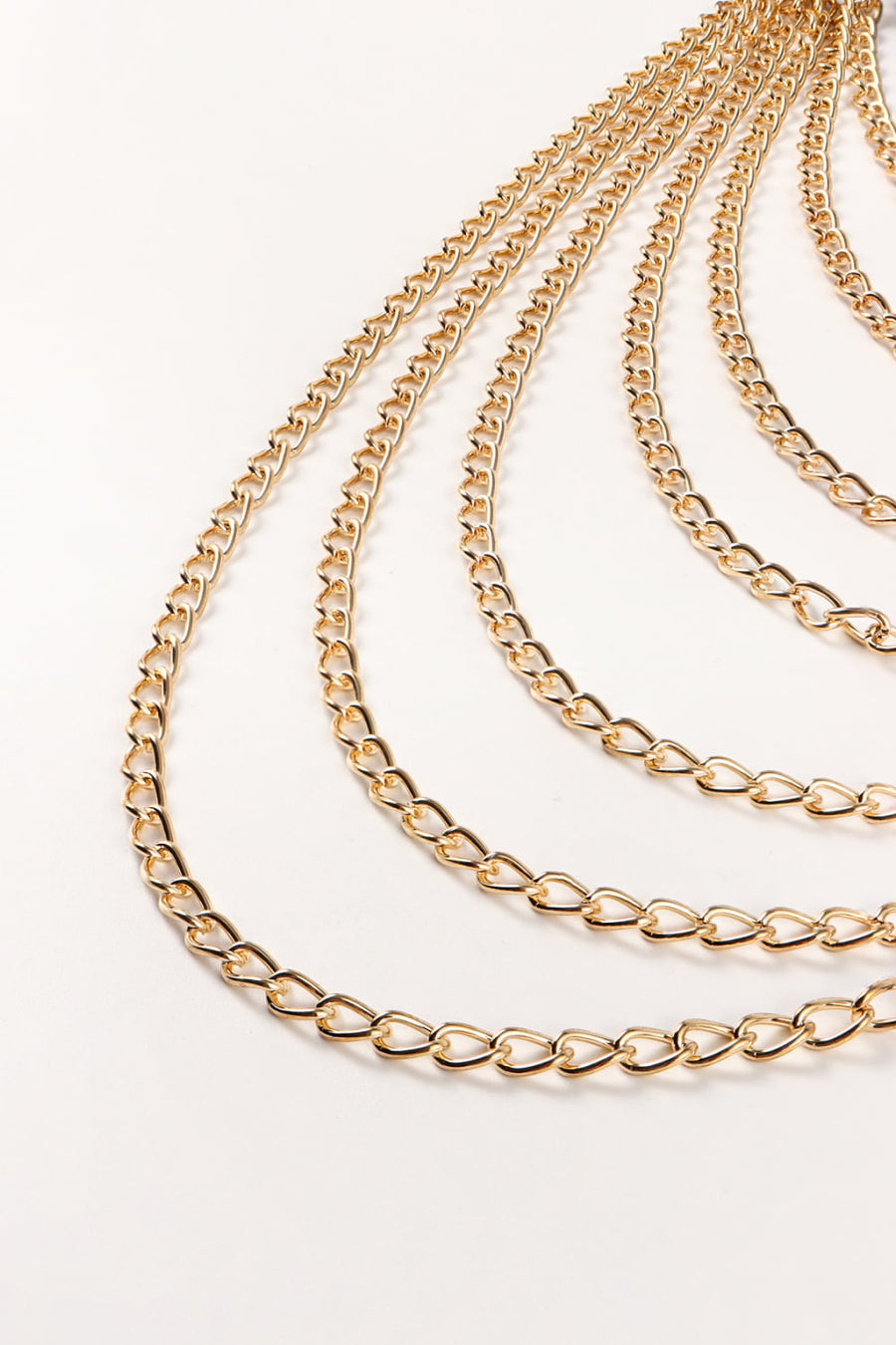 Cascading gold chain waist harness with multiple strands of aluminum links.