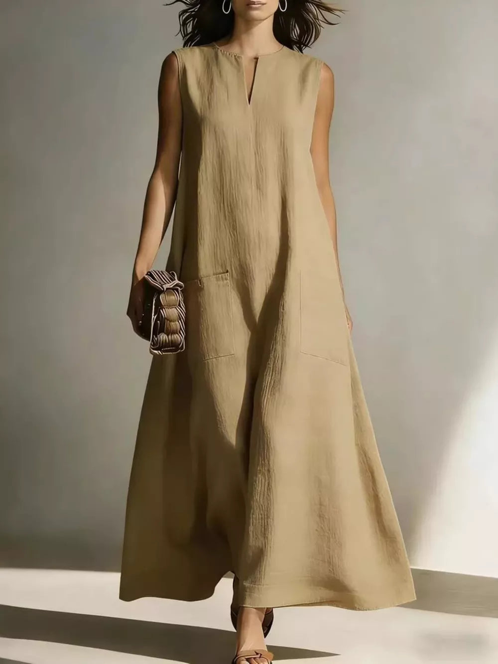 Maxi dress in beige linen blend with V-neck, sleeveless, and two large front pockets.