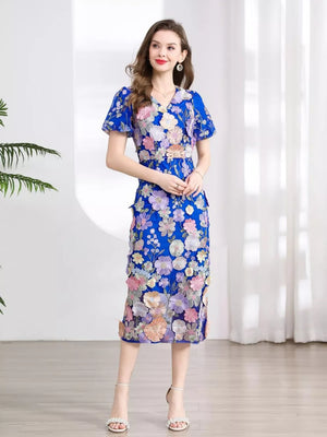 Blue floral embroidered midi dress with V-neck and short puff sleeves.